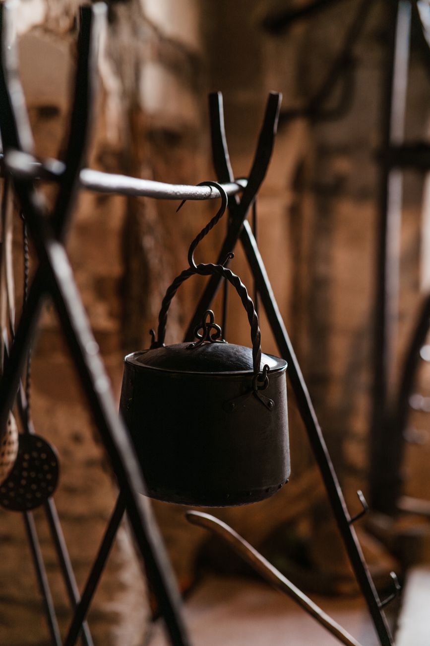A vintage kitchen with cookware hanging in soft light — the room a Smithey heirloom skillet lives in for the next generation.